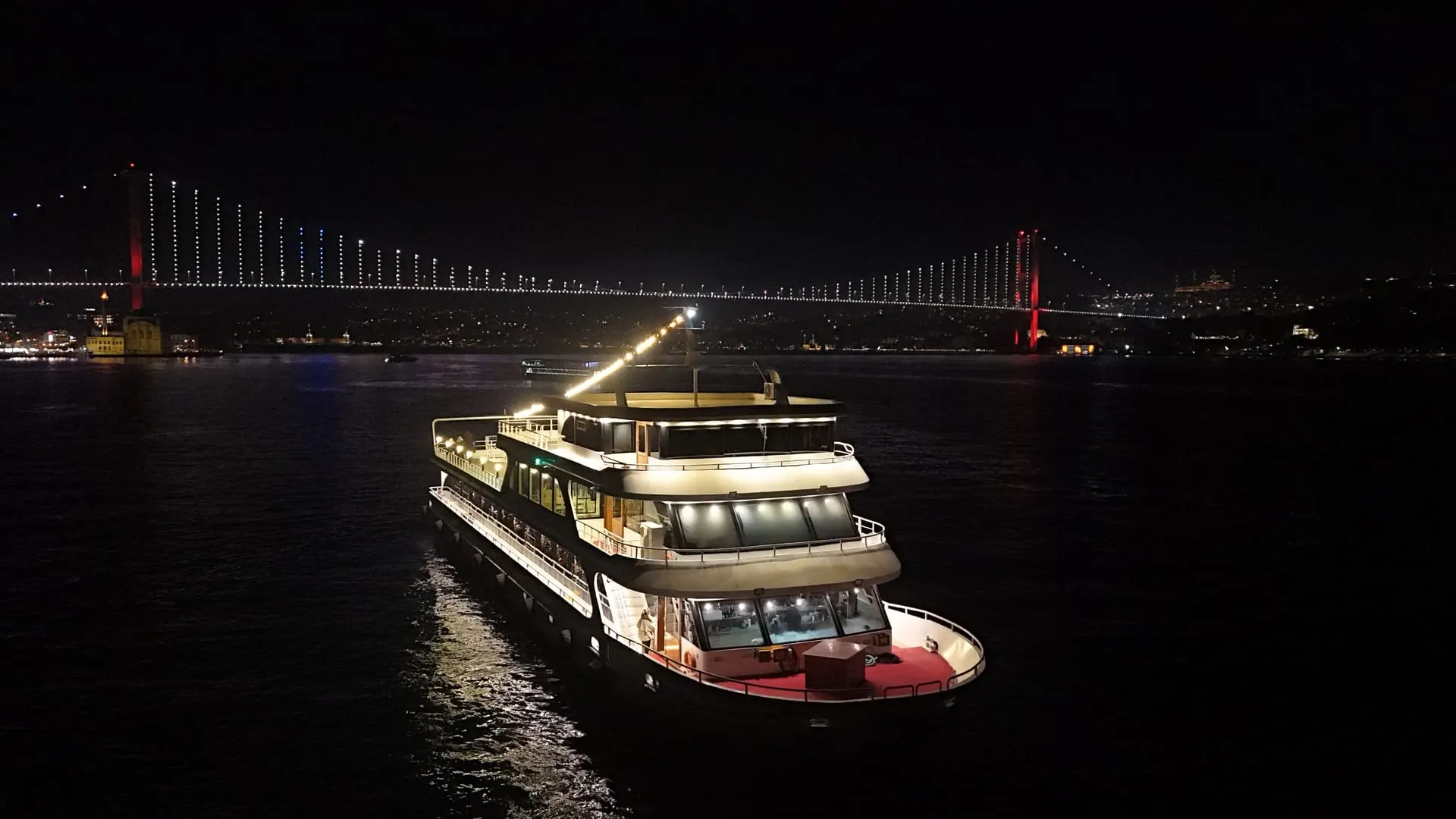 Our cruise vessel on the Bosphorus at night, the bridge illuminated behind