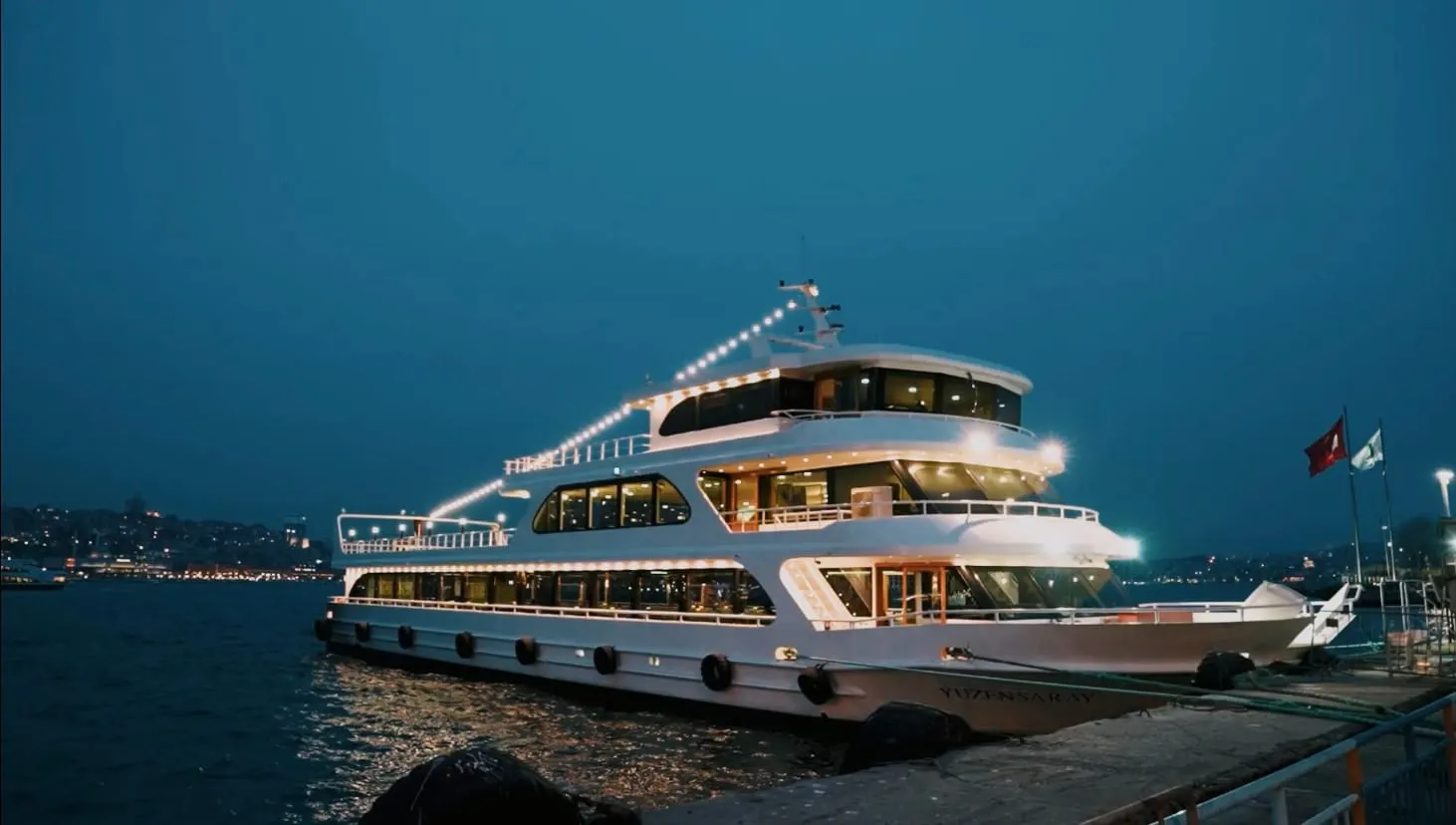 Our cruise vessel lit up at the pier as dusk falls over the Bosphorus