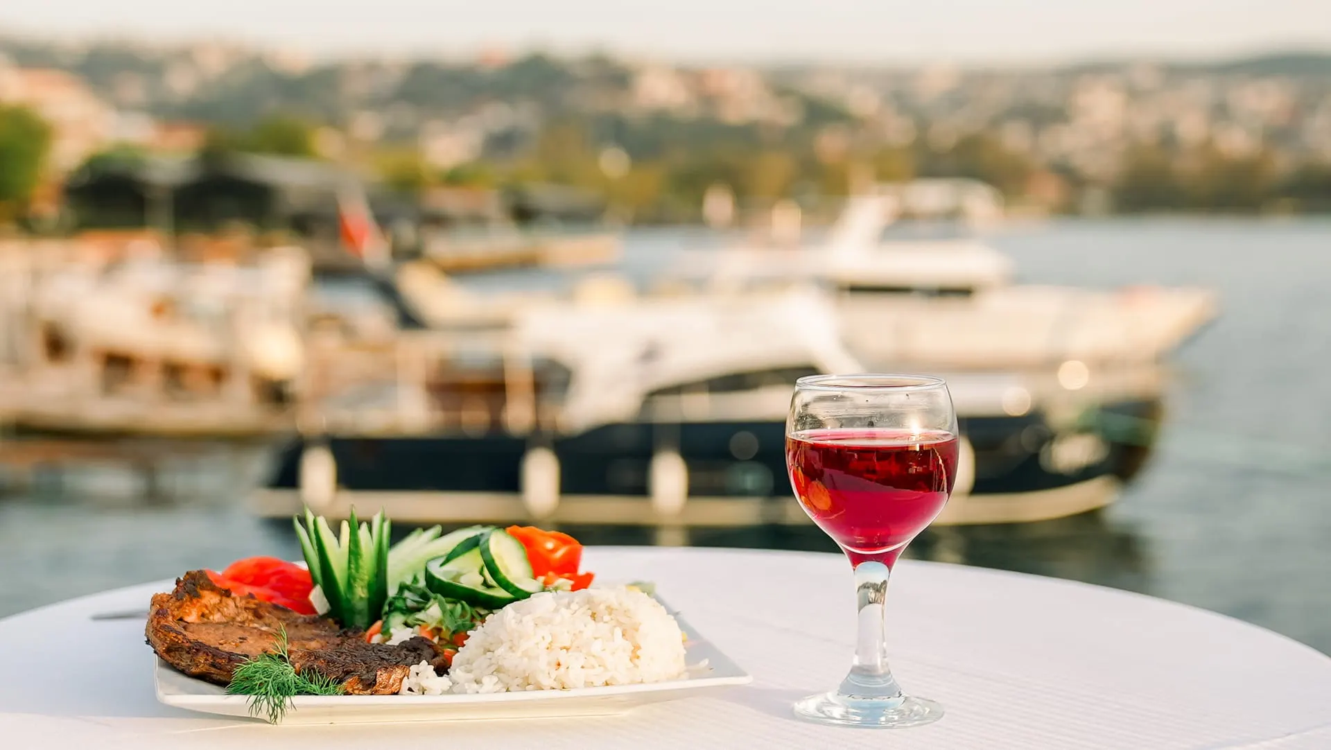 Grilled main course and red wine at a table overlooking the Bosphorus
